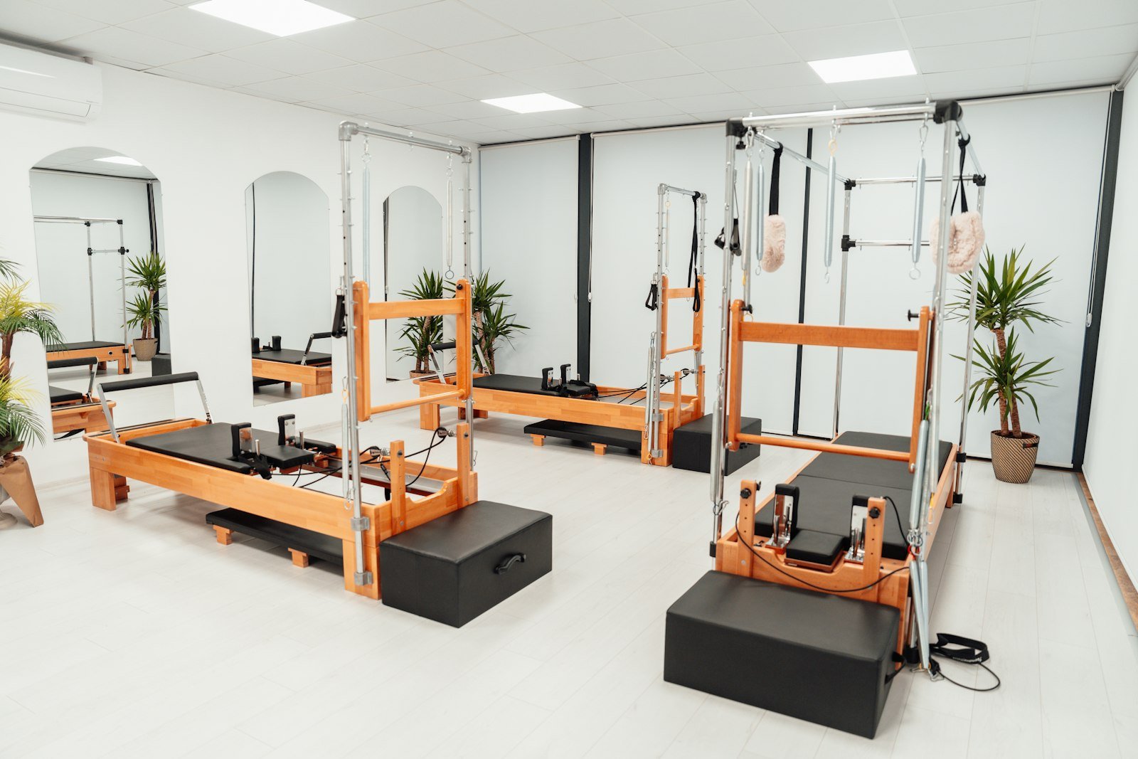 Bright clinical exercise studio with pilates reformer equipment and mirrored walls