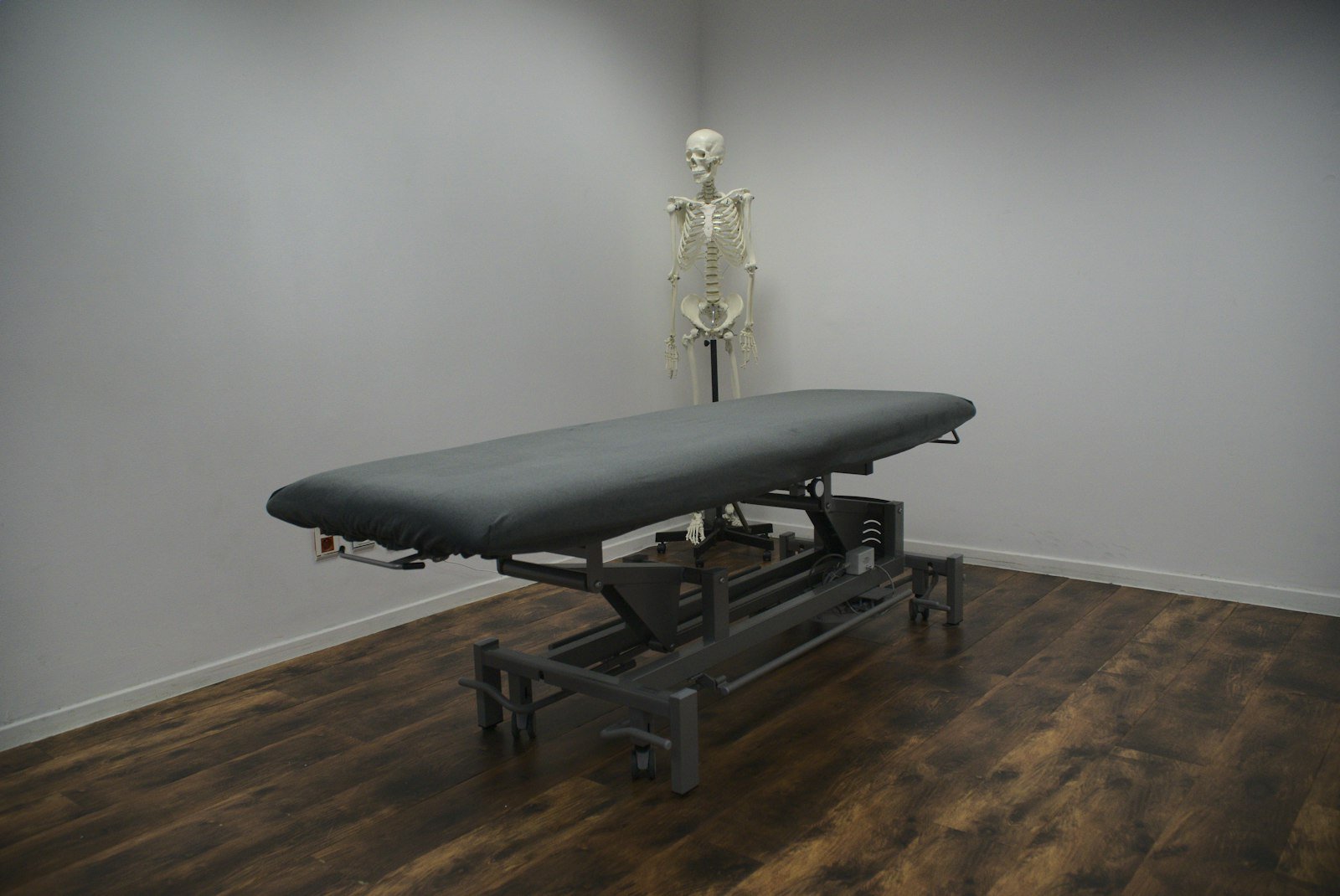 Physiotherapy treatment table and anatomical skeleton model in a clinic room
