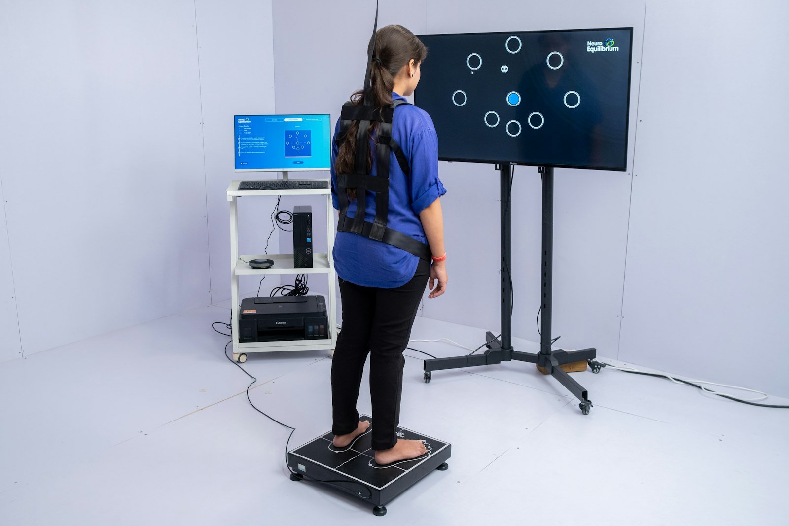 Patient standing on a digital balance-assessment plate during a posture screening