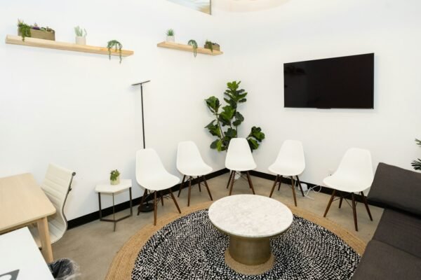 Calm, modern waiting room with white chairs and plants, the kind of space a workcover psychologist practises in.