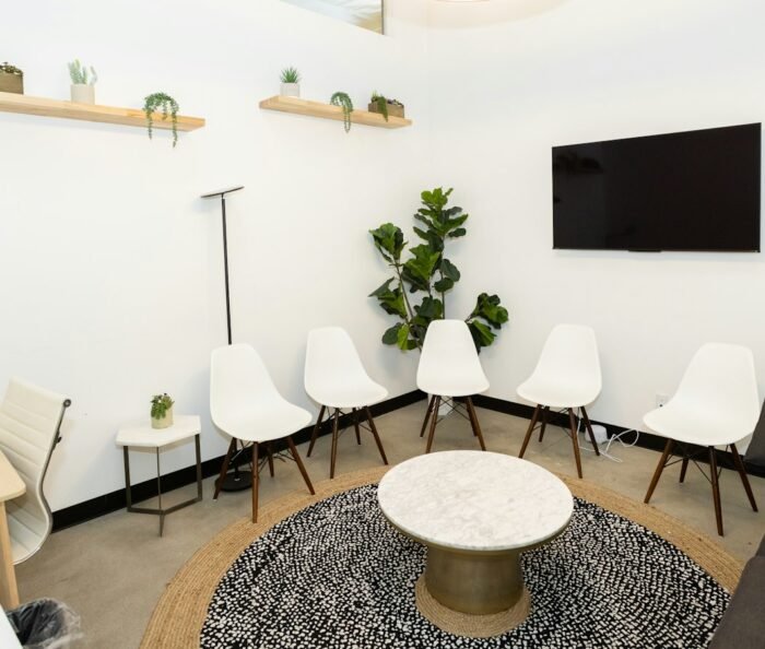 Calm, modern waiting room with white chairs and plants, the kind of space a workcover psychologist practises in.