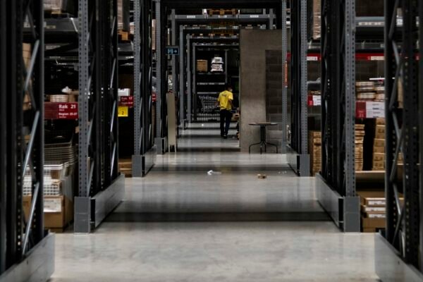 Warehouse aisle stacked with boxes, representing the physical roles needing a pre-employment medical assessment.